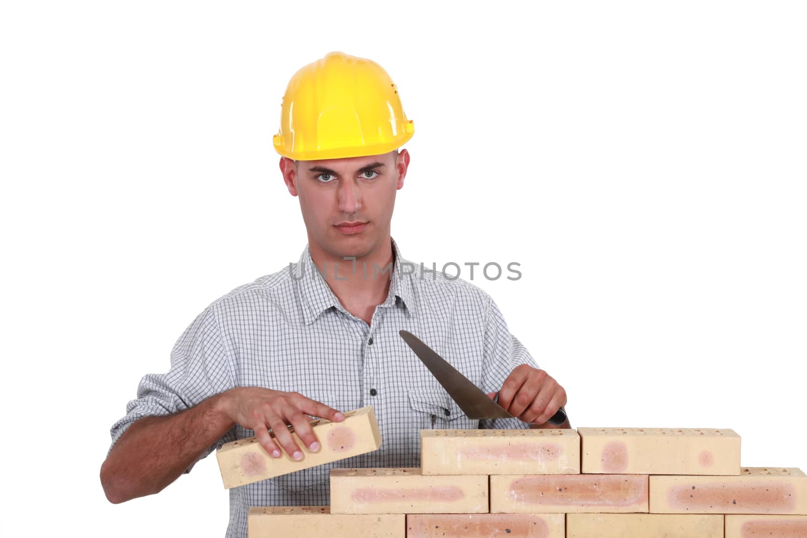 A mason working on a wall. by phovoir