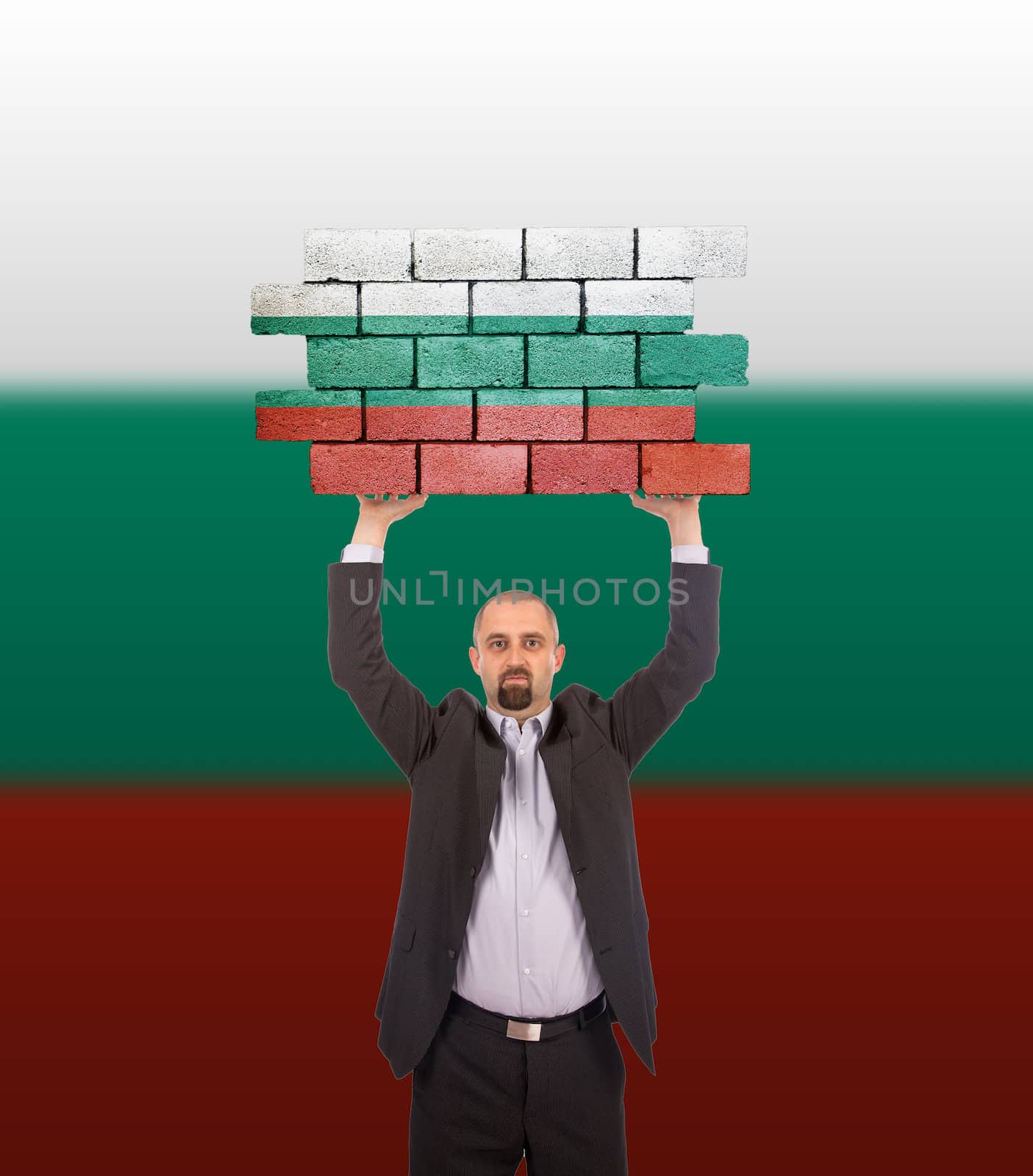 Businessman holding a large piece of a brick wall, flag of Bulgaria, isolated on national flag