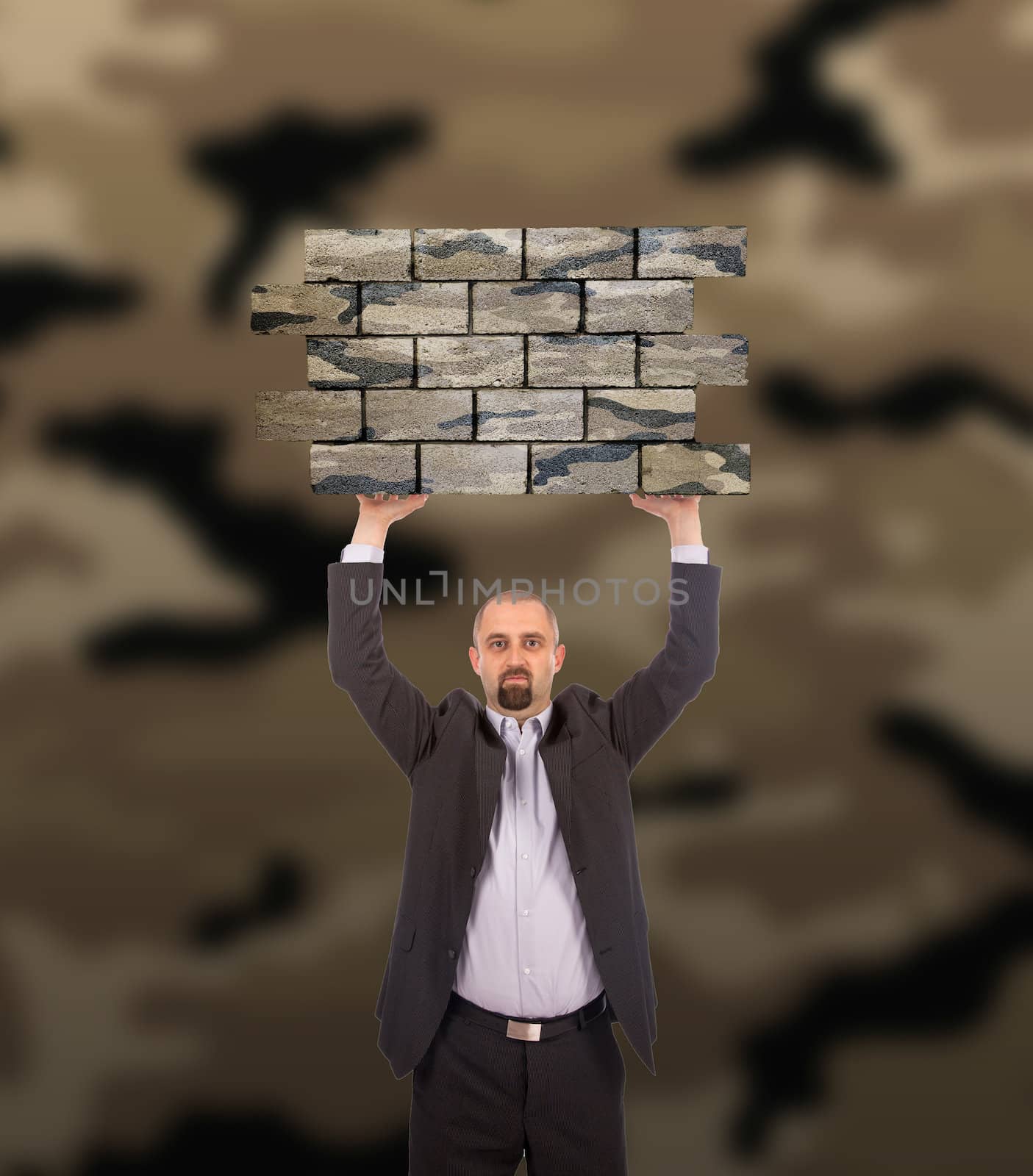 Businessman holding a large piece of a brick wall, camouflage pattern , isolated