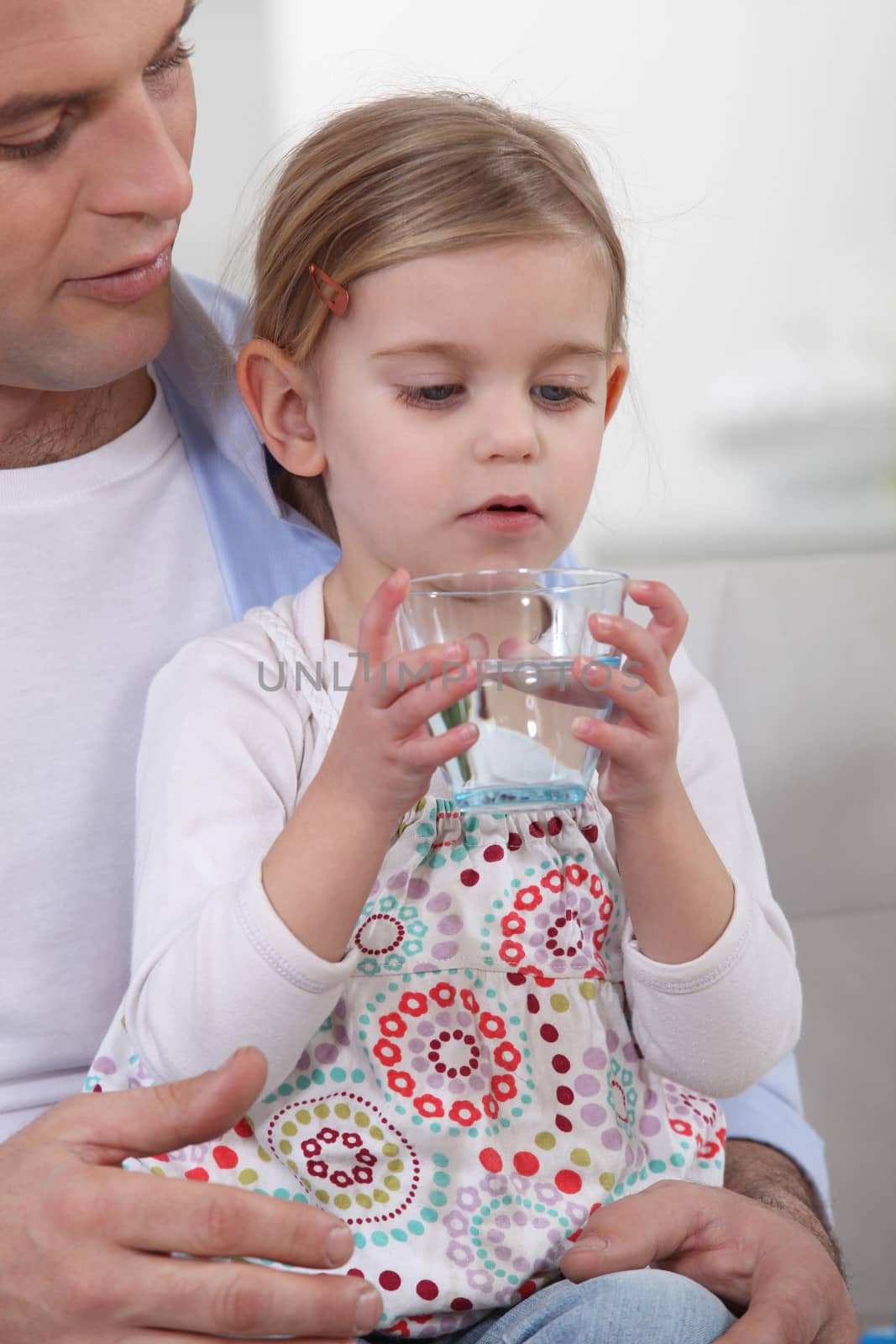 Father giving his daughter water by phovoir