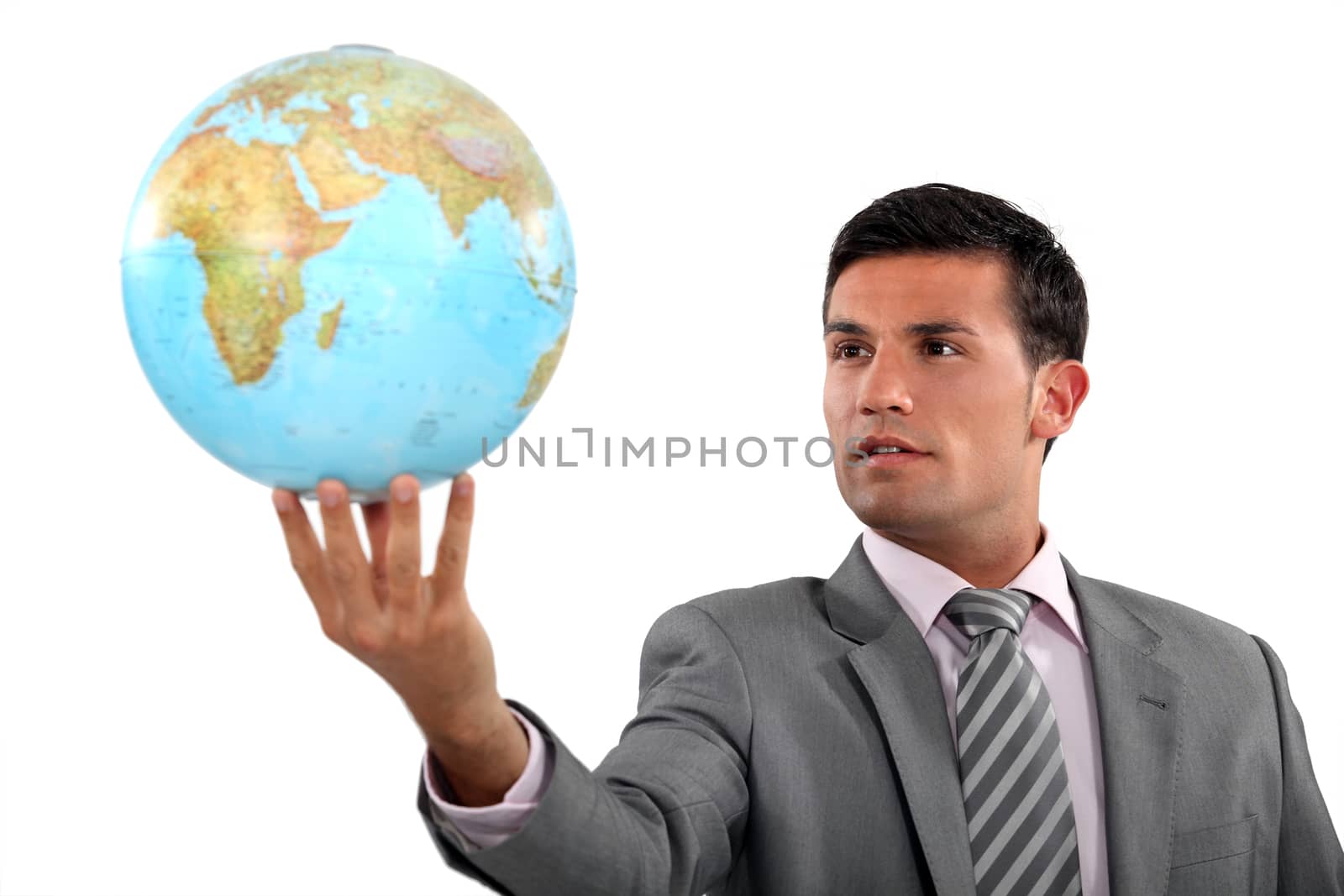 Ambitious businessman with globe in hand by phovoir
