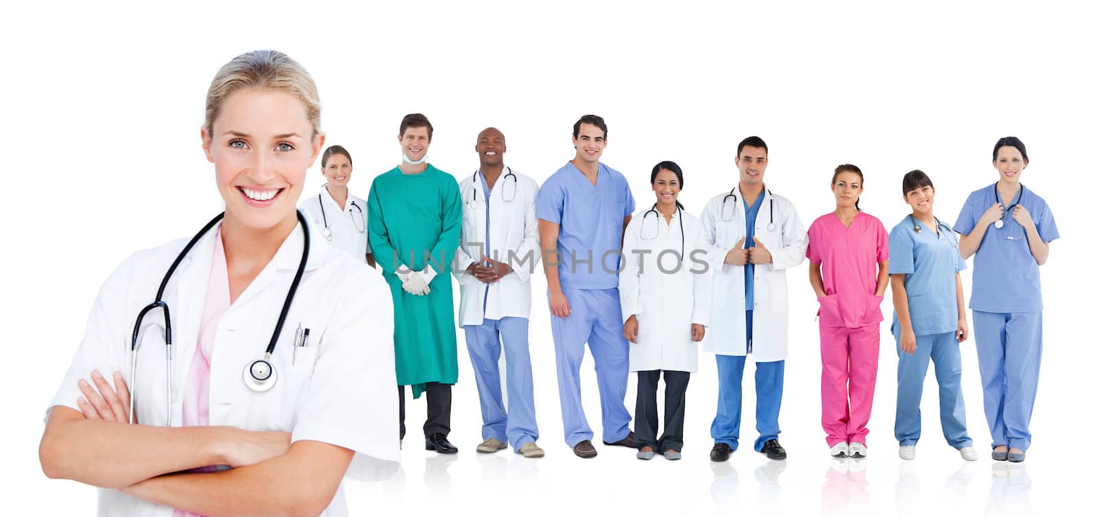 Smiling doctor standing in front of her medical team in line on white background