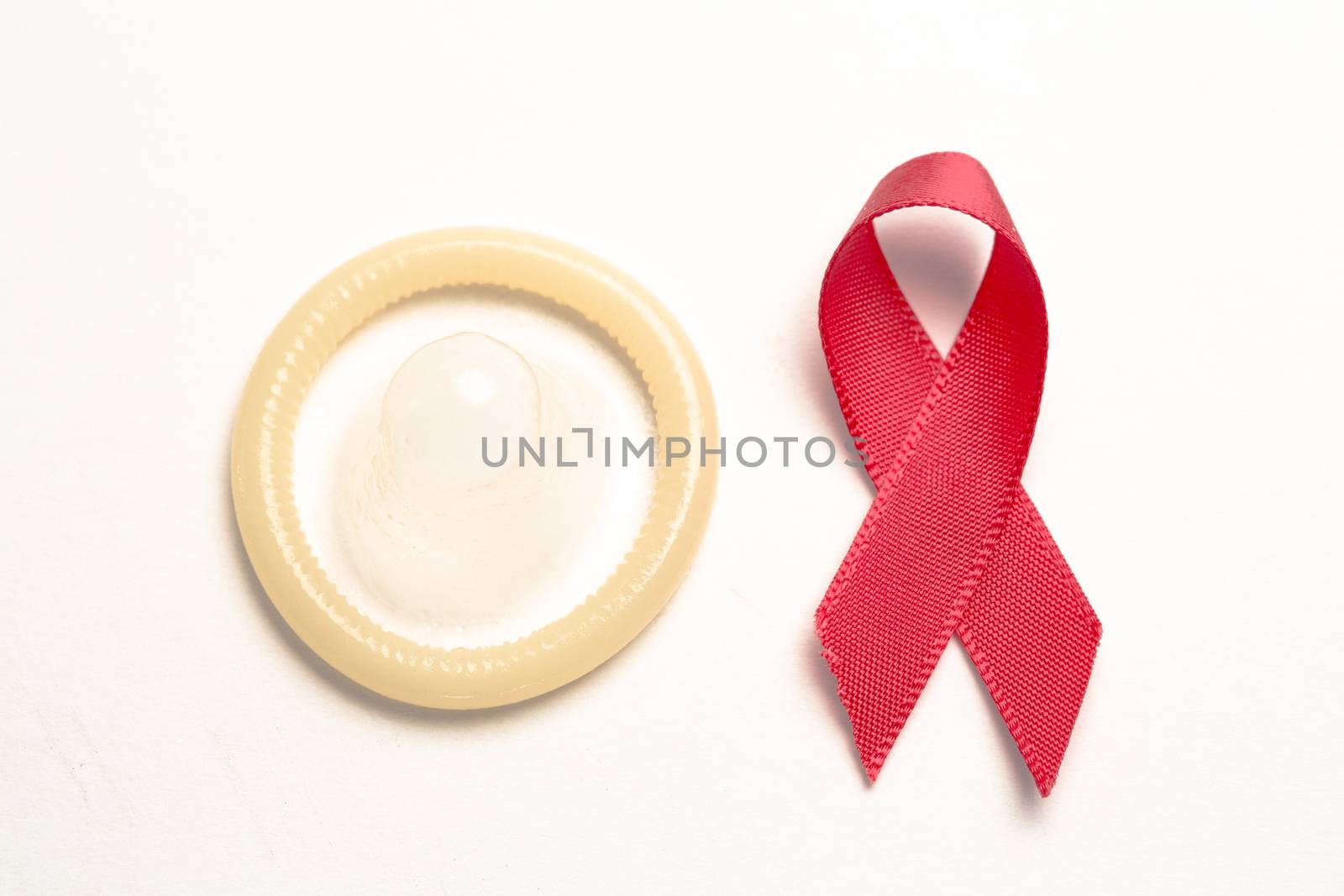 Red awareness ribbon and condom by Wavebreakmedia
