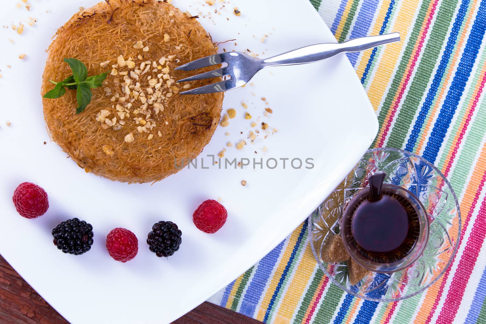 Kunefe and Turkish hot Tea on a picnic Table by coskun