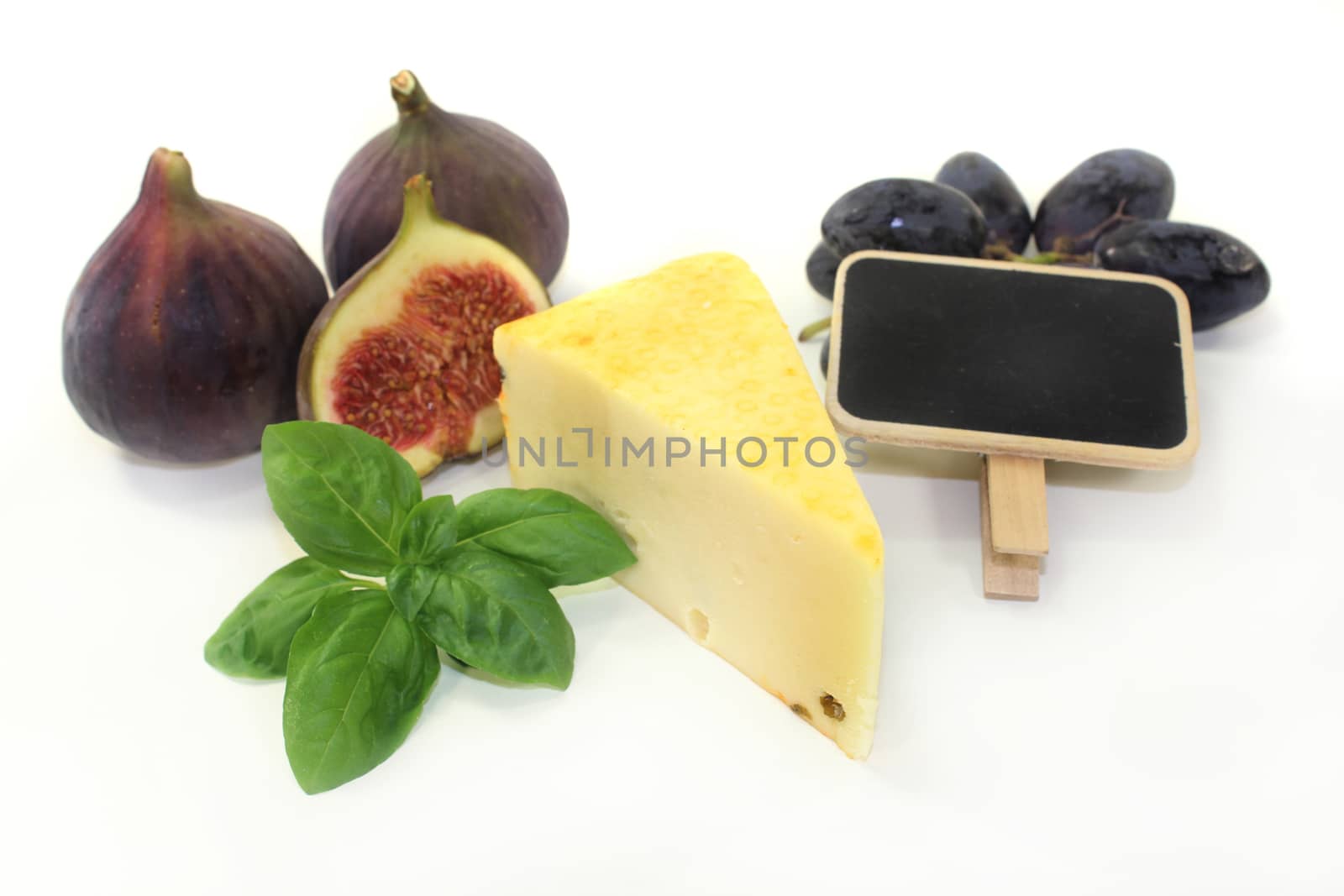 a piece of cheese with a cheese knife and basil