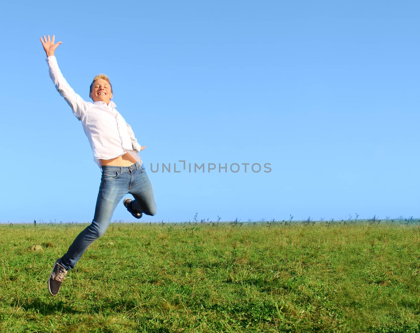 Man jumping on summer field by destillat