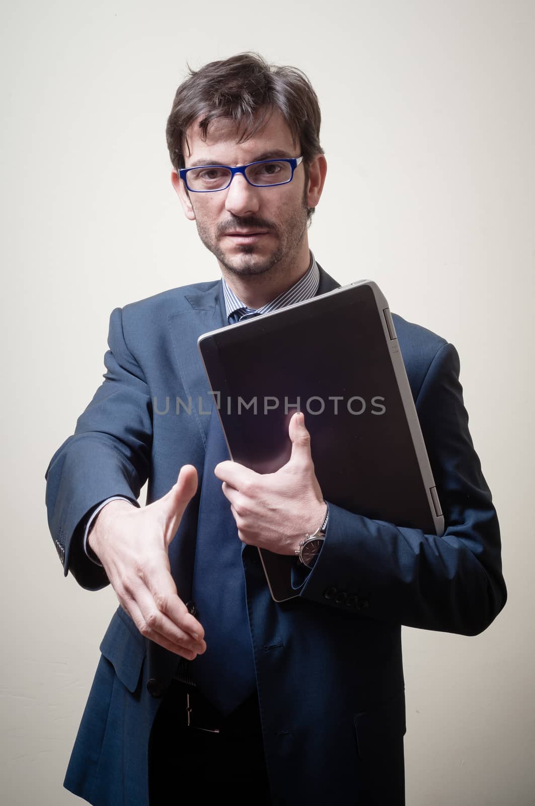 businessman with notebook holding out his hand on gray background