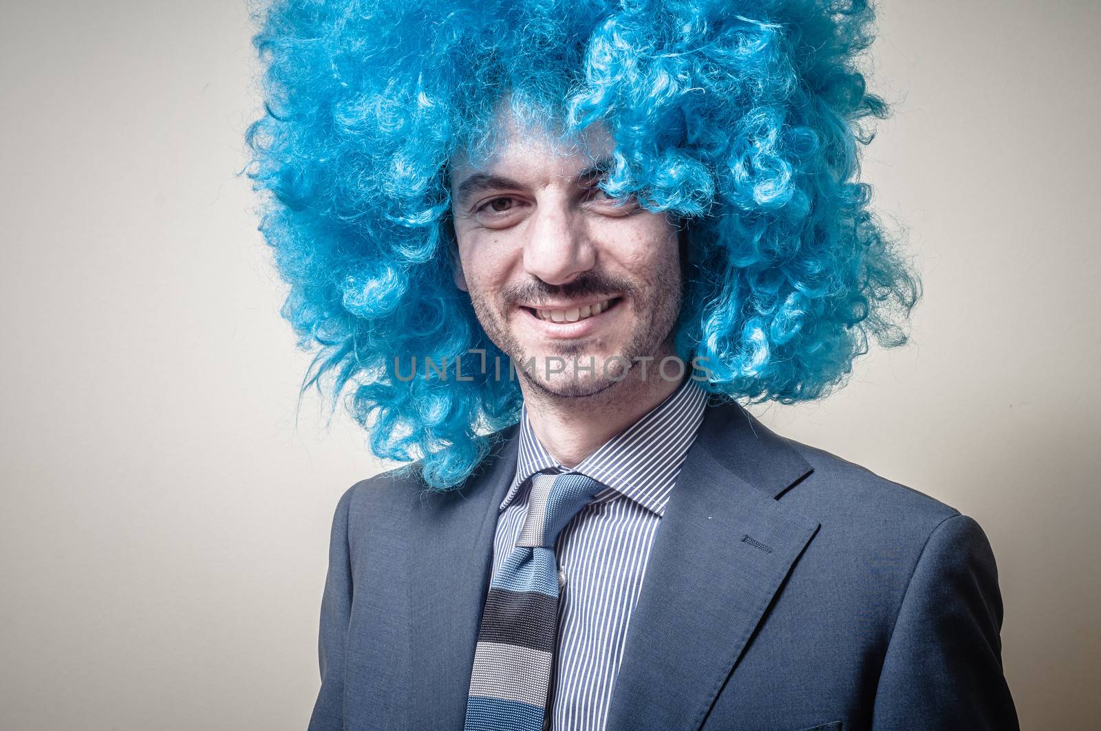 funny businessman with blue wig on  gray background