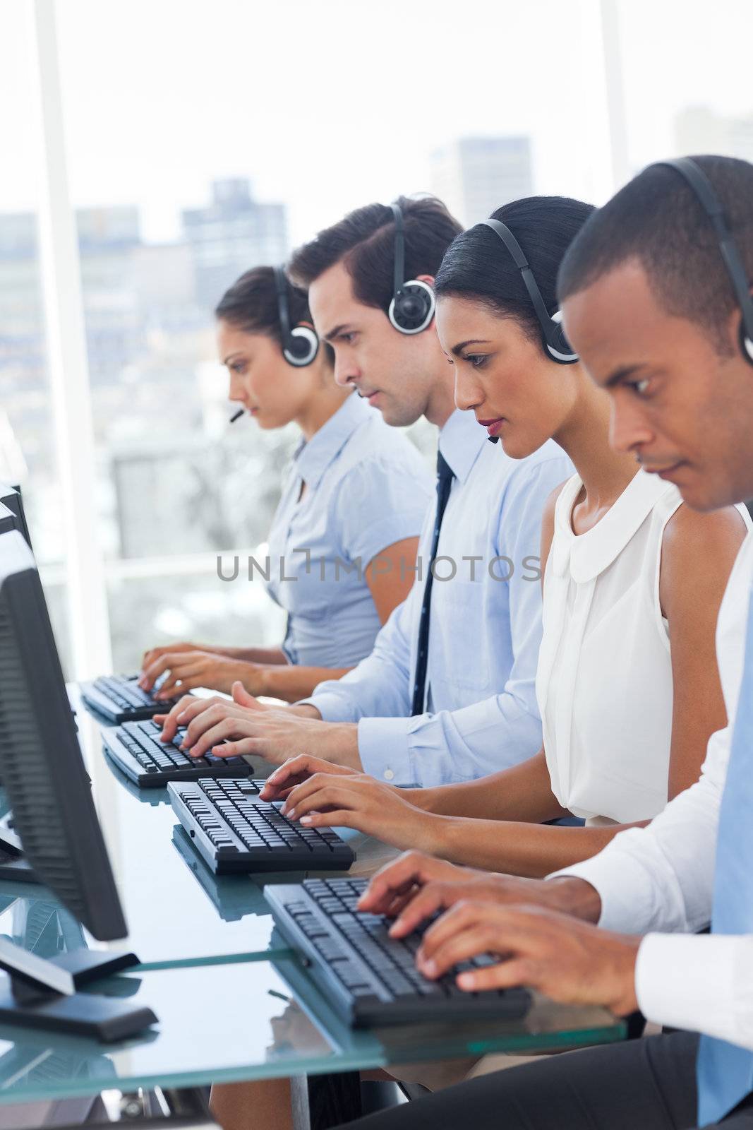 Call center employees sitting in line in a workplace