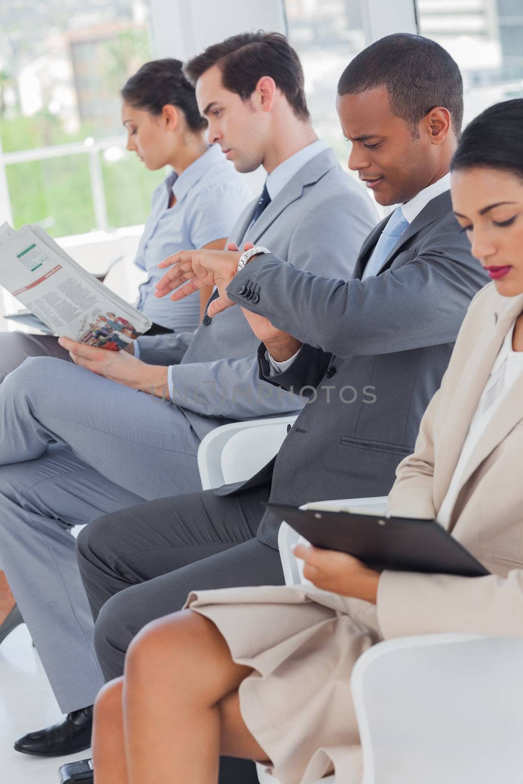 Business people sat in line in a waiting room