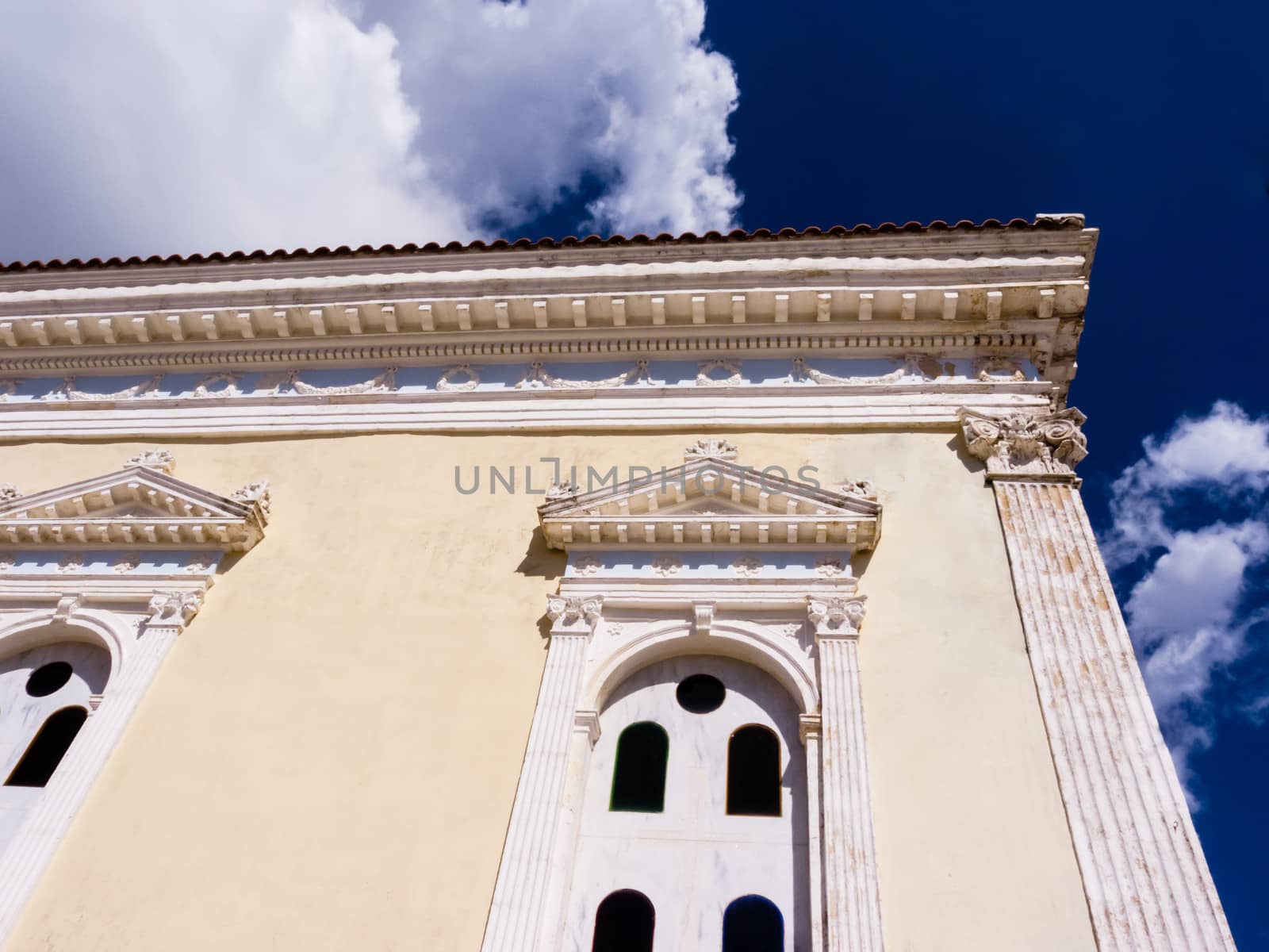 Part of a church wall with a background of cloudy blue sky