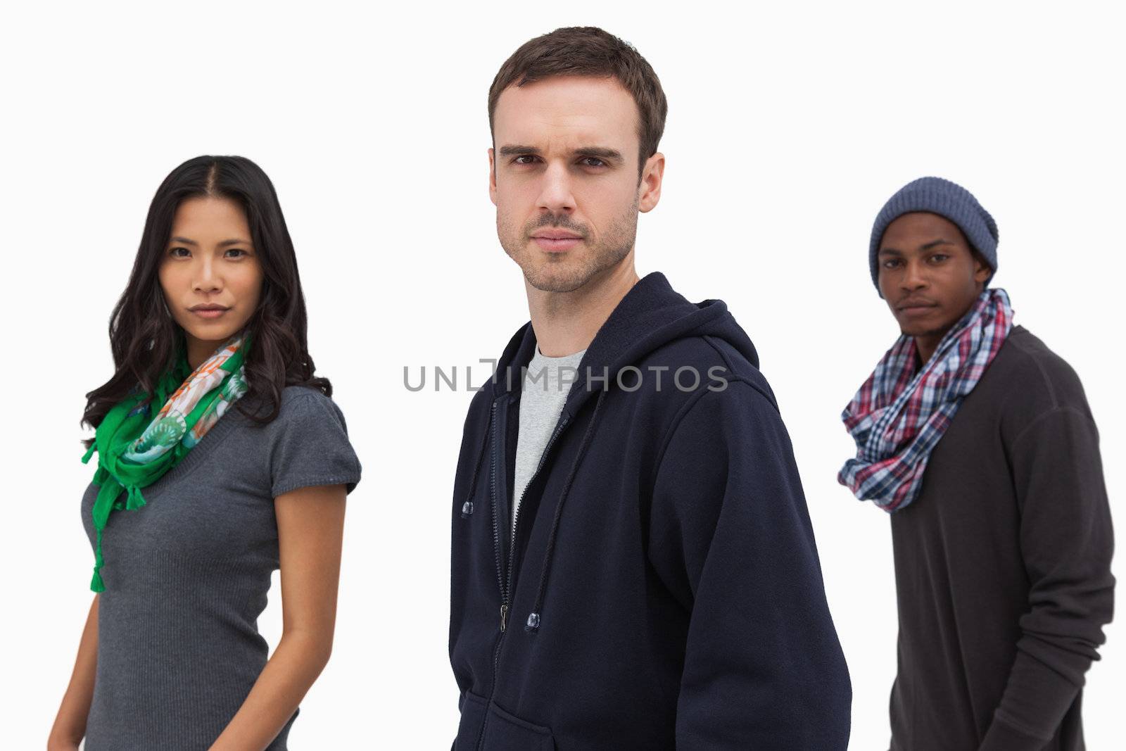 Serious stylish young people in a line on white background