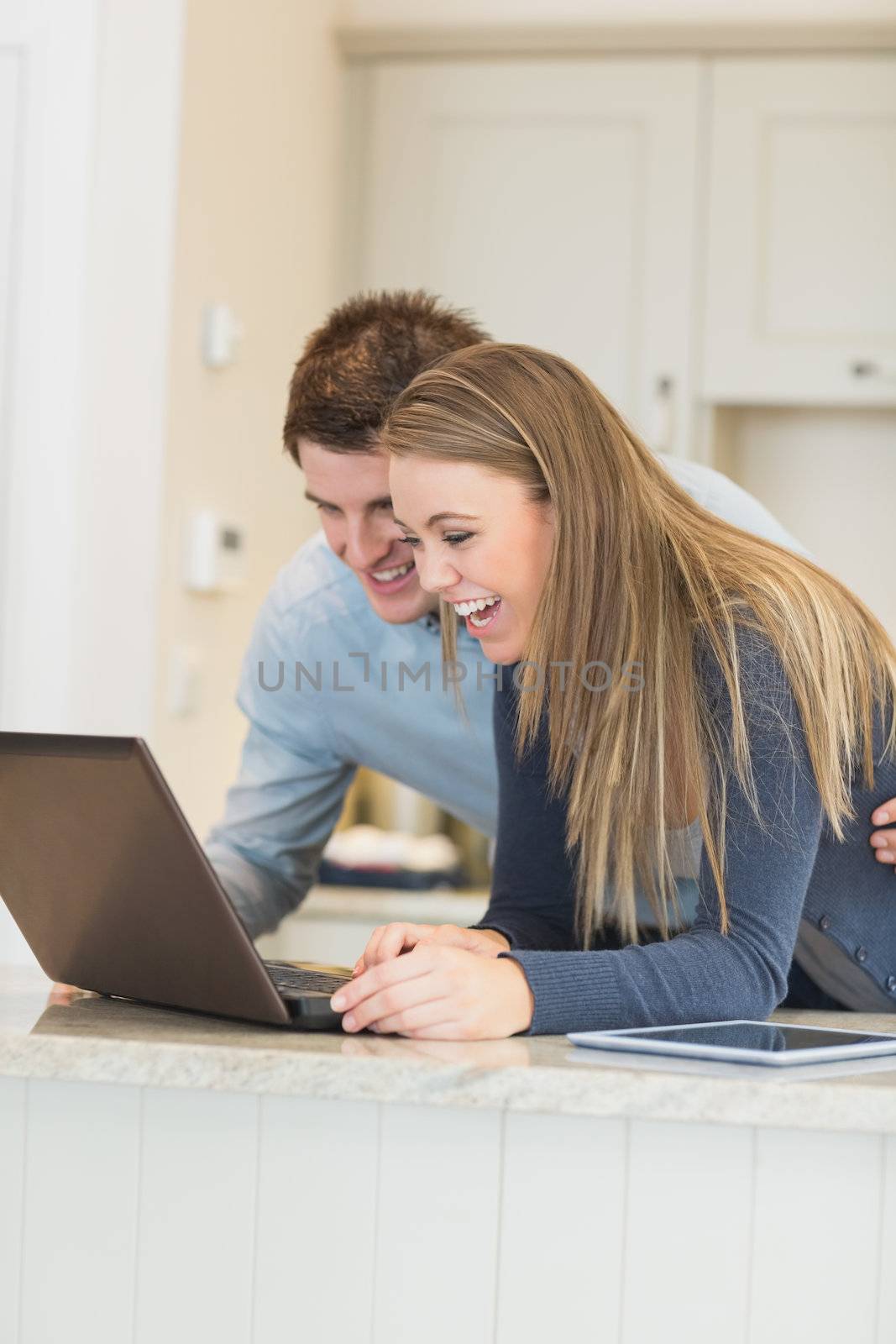Couple communicating via internet in kitchen