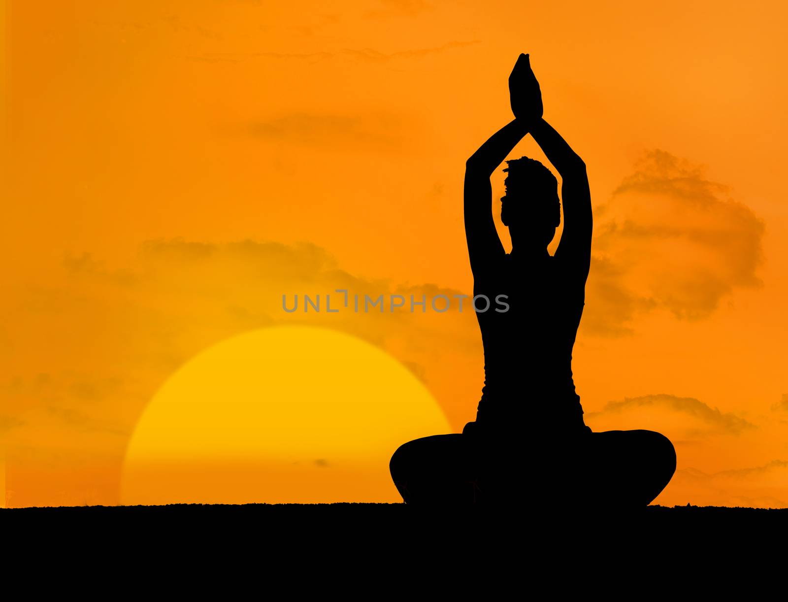 Calm silhouette of woman doing yoga under the sunset