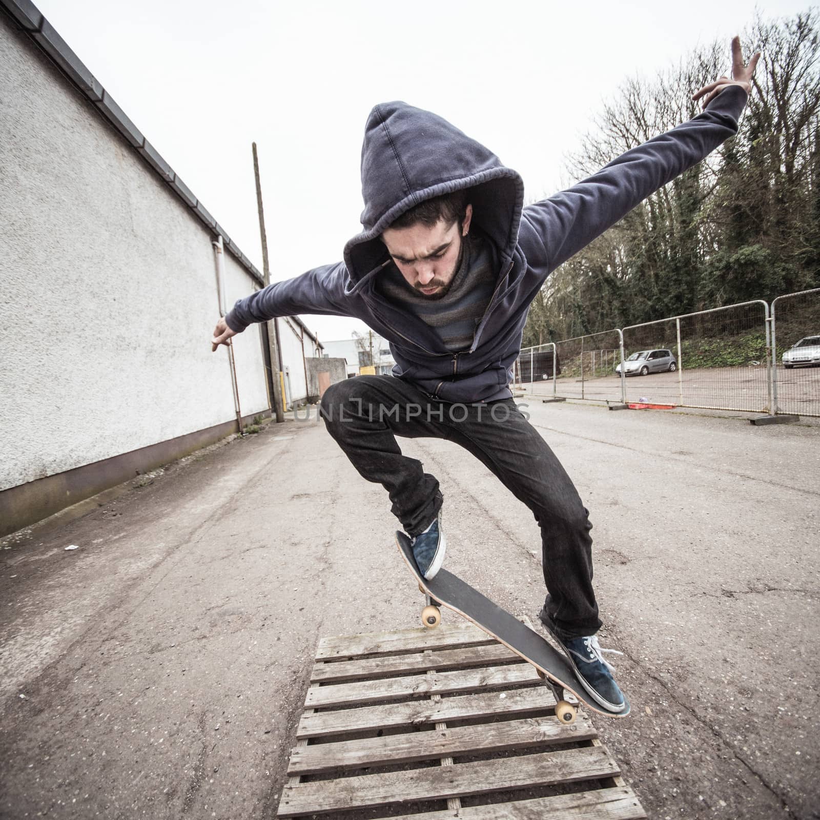 Skater doing ollie over wooden crate by Wavebreakmedia