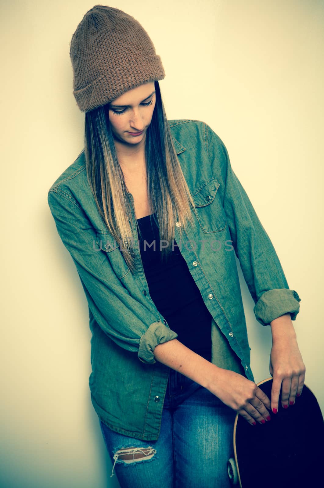 Young brunette woman posing with a skateboard