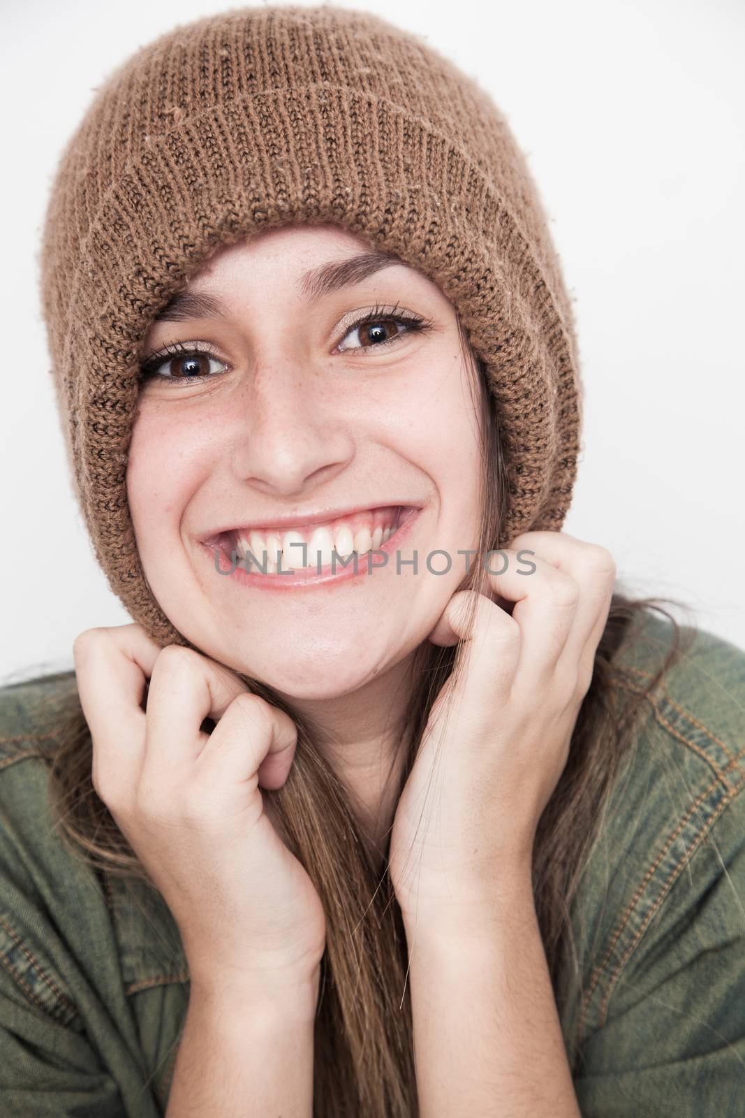 Young brunette woman doing funny face with brown hat