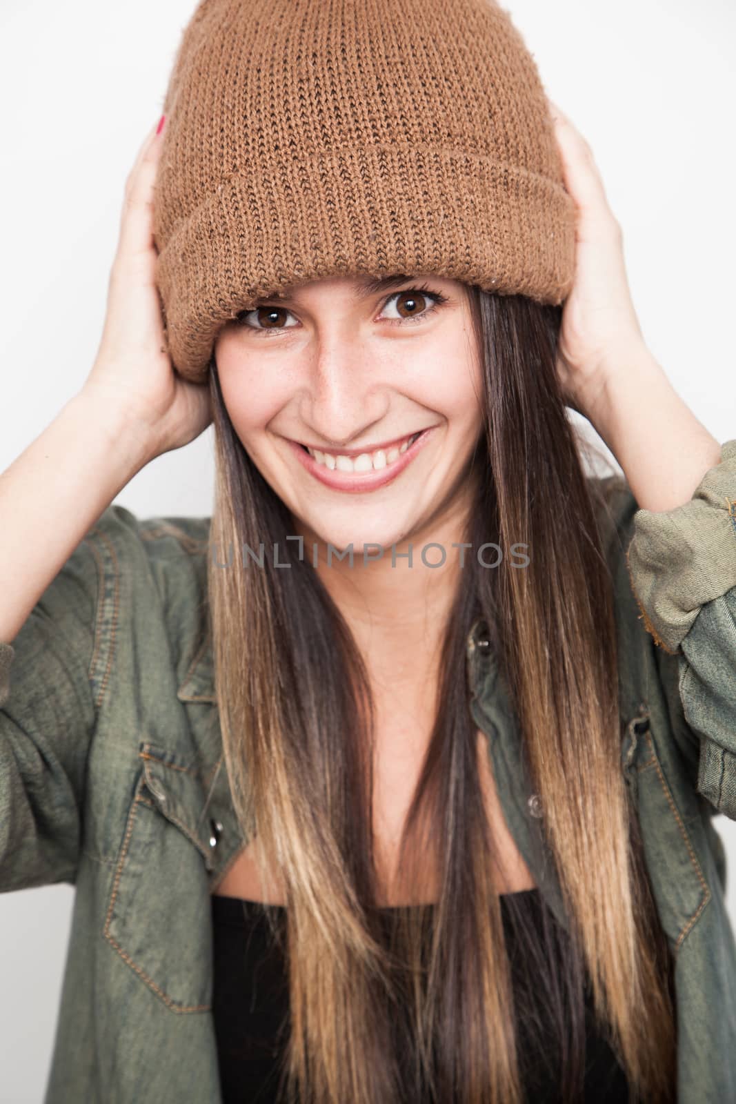 Young brunette woman doing funny face with brown hat