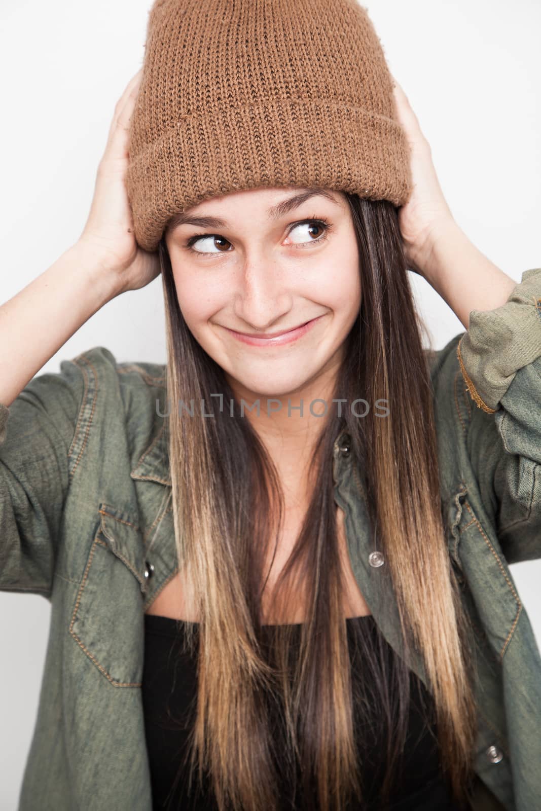 Young brunette woman doing funny face with brown hat