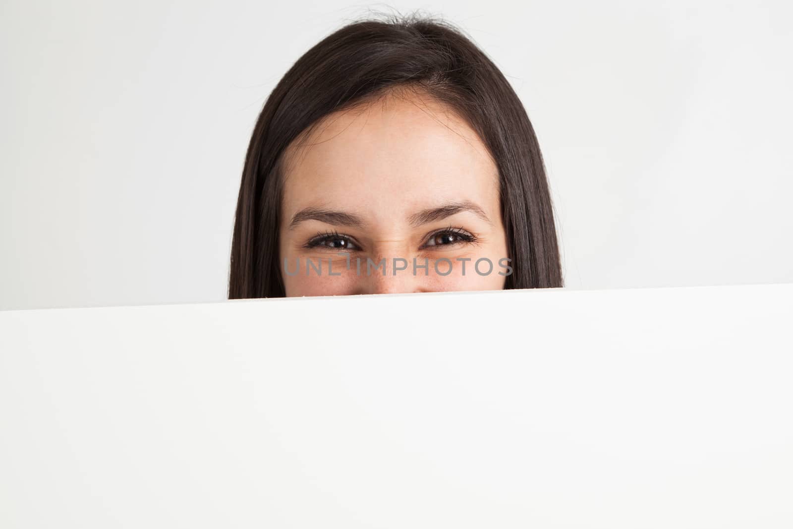 Young woman holding a white board by Izaphoto