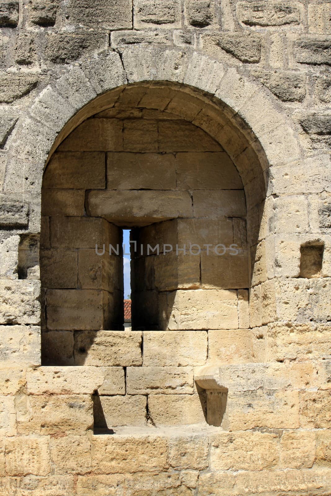 Close up on one loop hole in famous fortification wall surrounding Aigues-Mortes city, Camargue, France