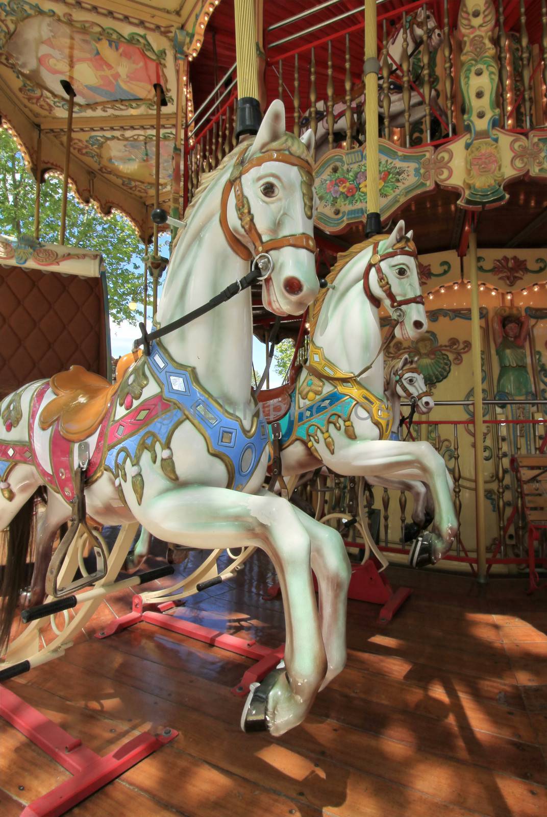 Close up of the inside of a colorful carousel with two beautiful white horses