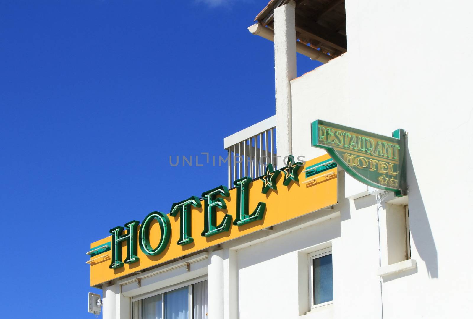 Small two stars hotel and restaurant signs on white building by beautiful day