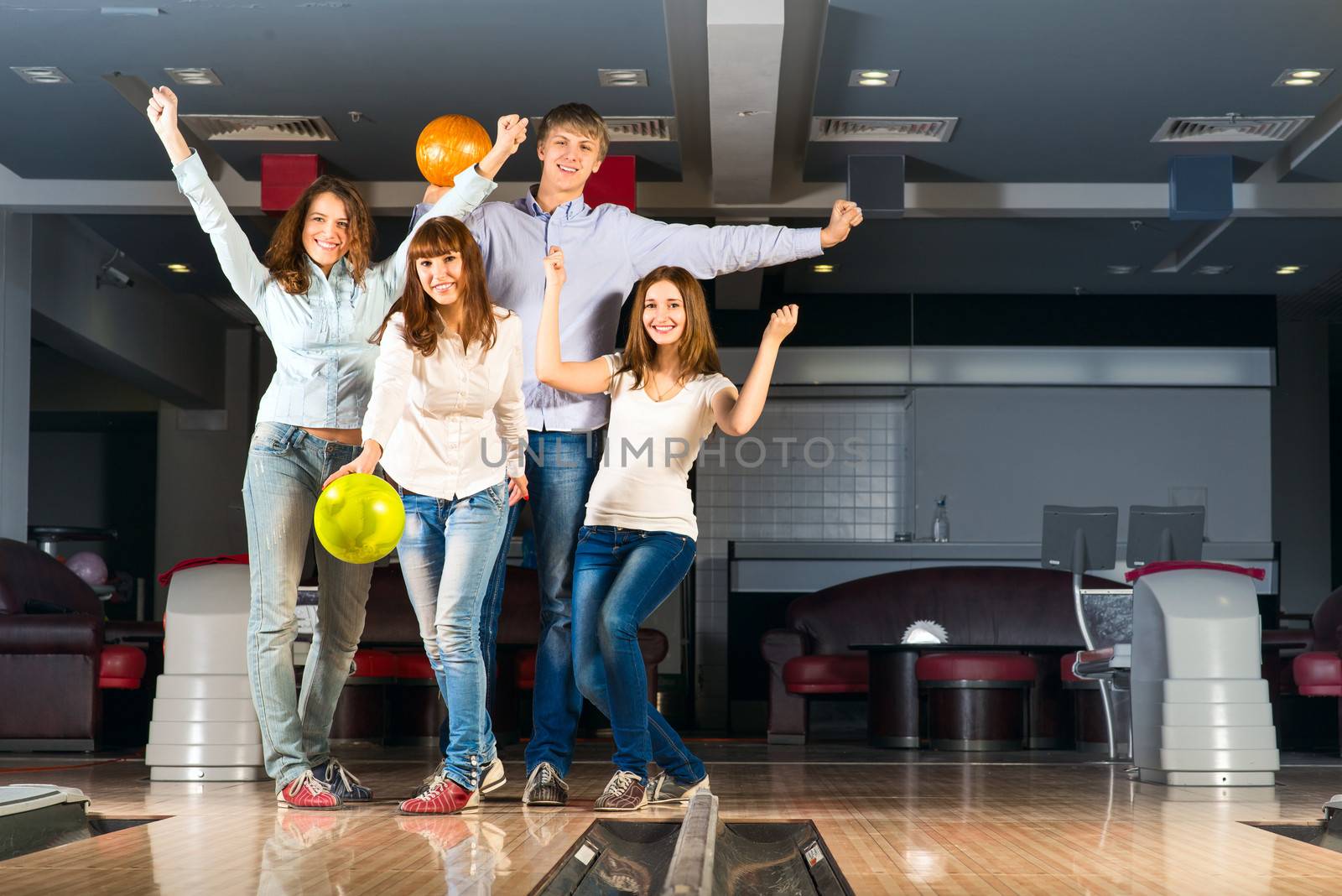 Group of young friends playing bowling, spending time with friends