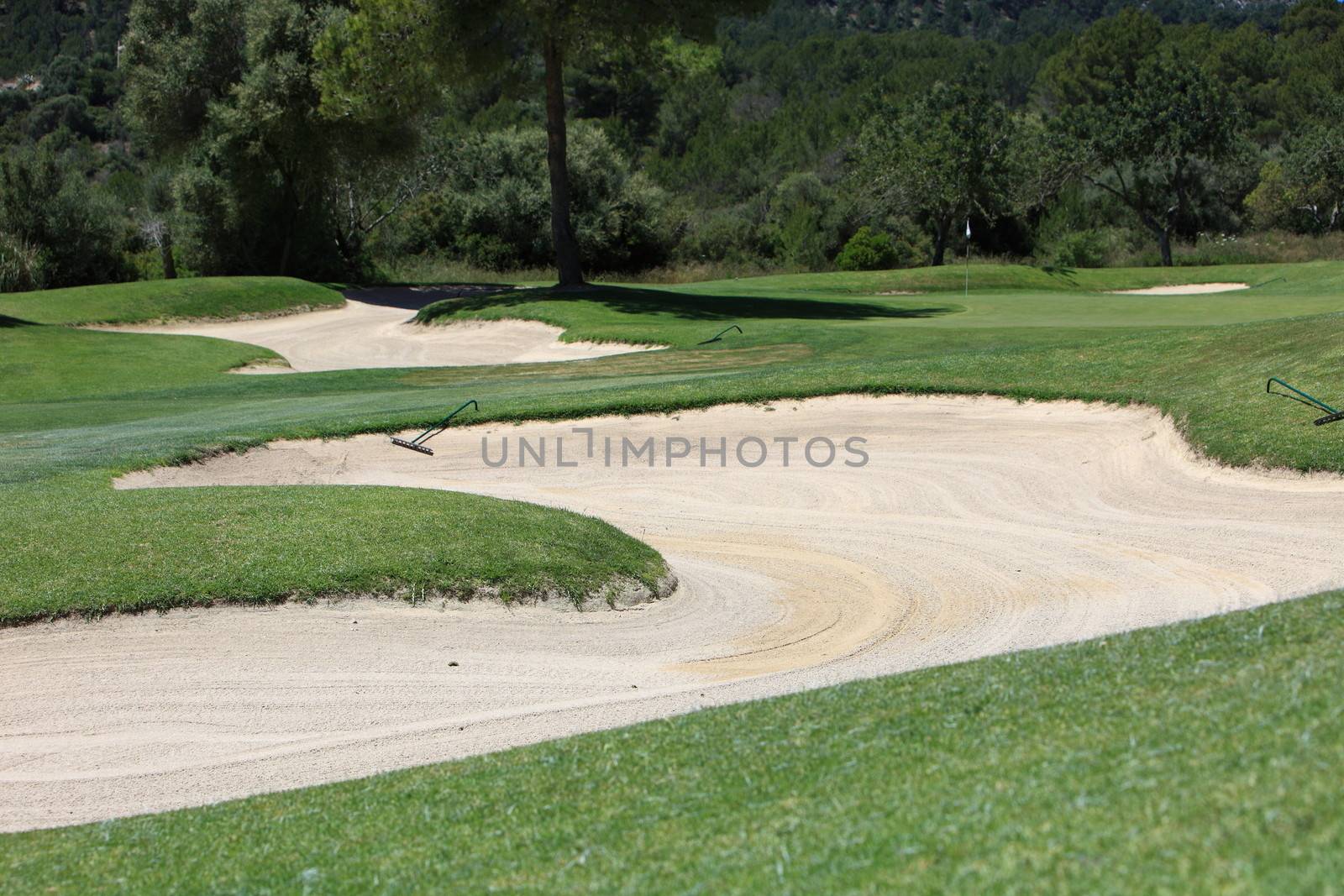 Sand trap or bunker on a manicured fairway on a golf course designed as a hazard and penalty for the player