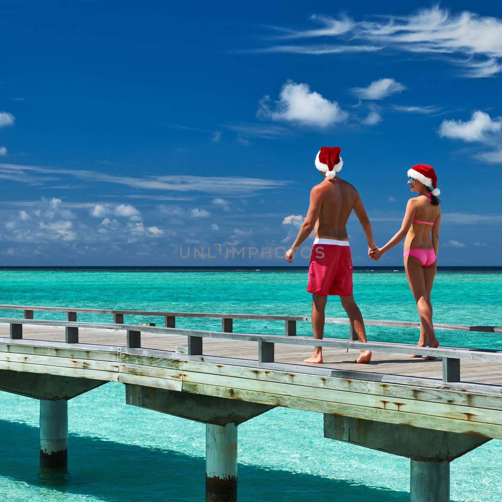 Couple on a tropical beach jetty at Maldives