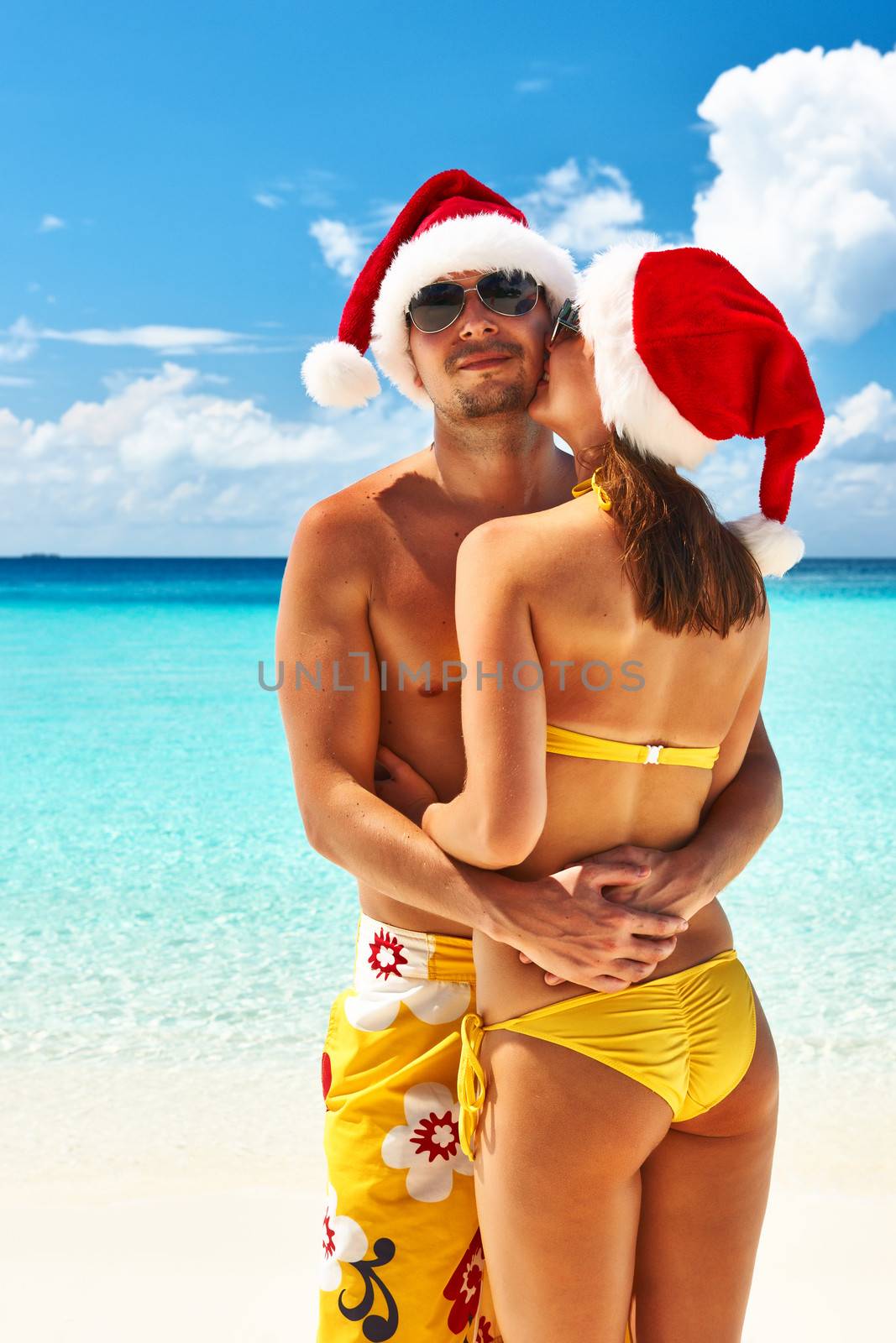 Couple in santa's hat on a beach at Maldives by haveseen