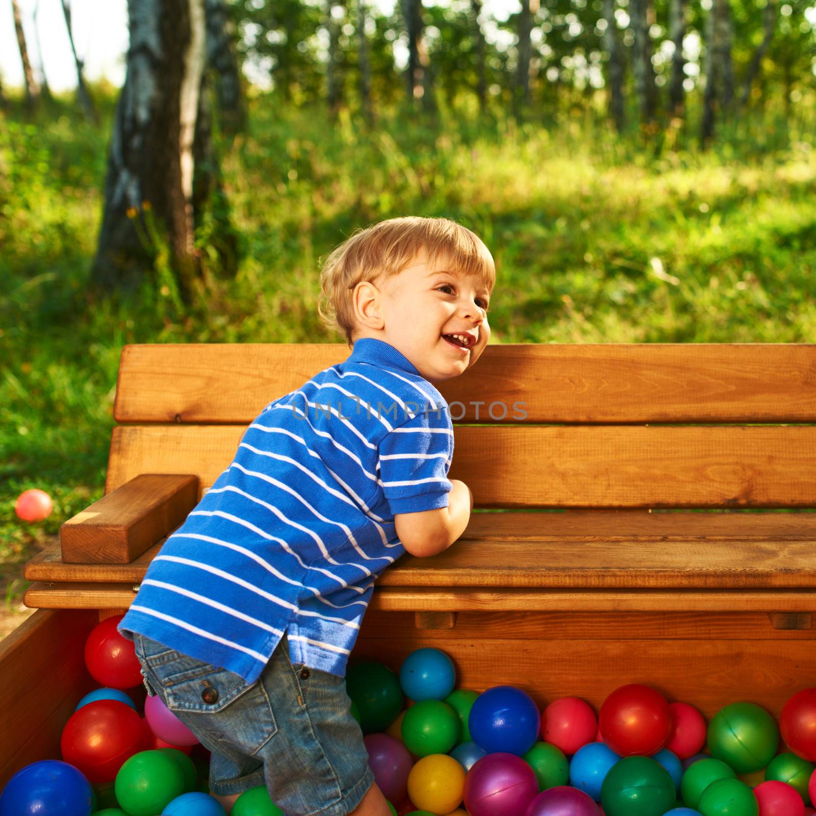 Happy child playing at colorful plastic balls playground high view