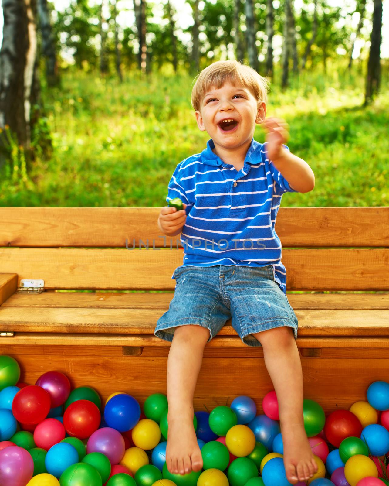 Happy child playing at colorful plastic balls playground high view