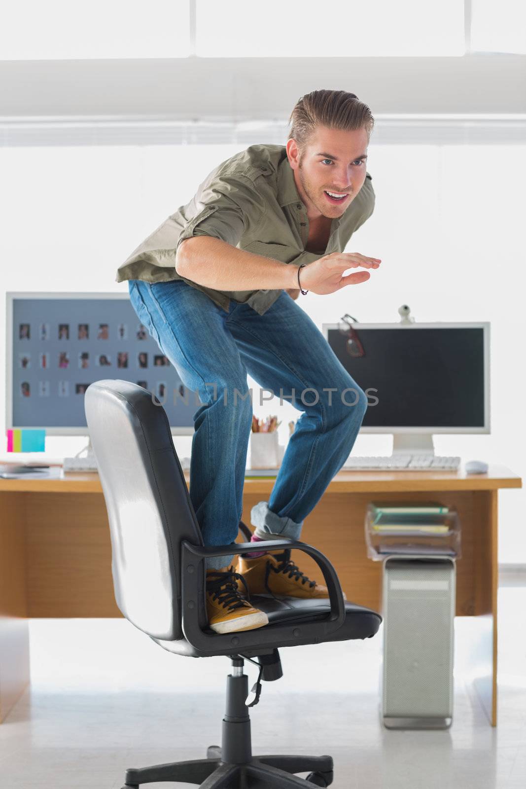 Handsome man surfing his office chair and having fun