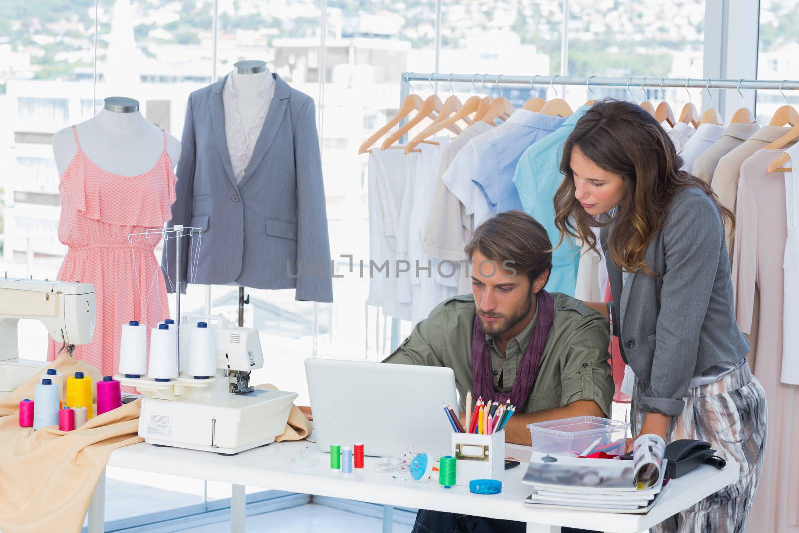 Two fashion designers working on laptop by Wavebreakmedia