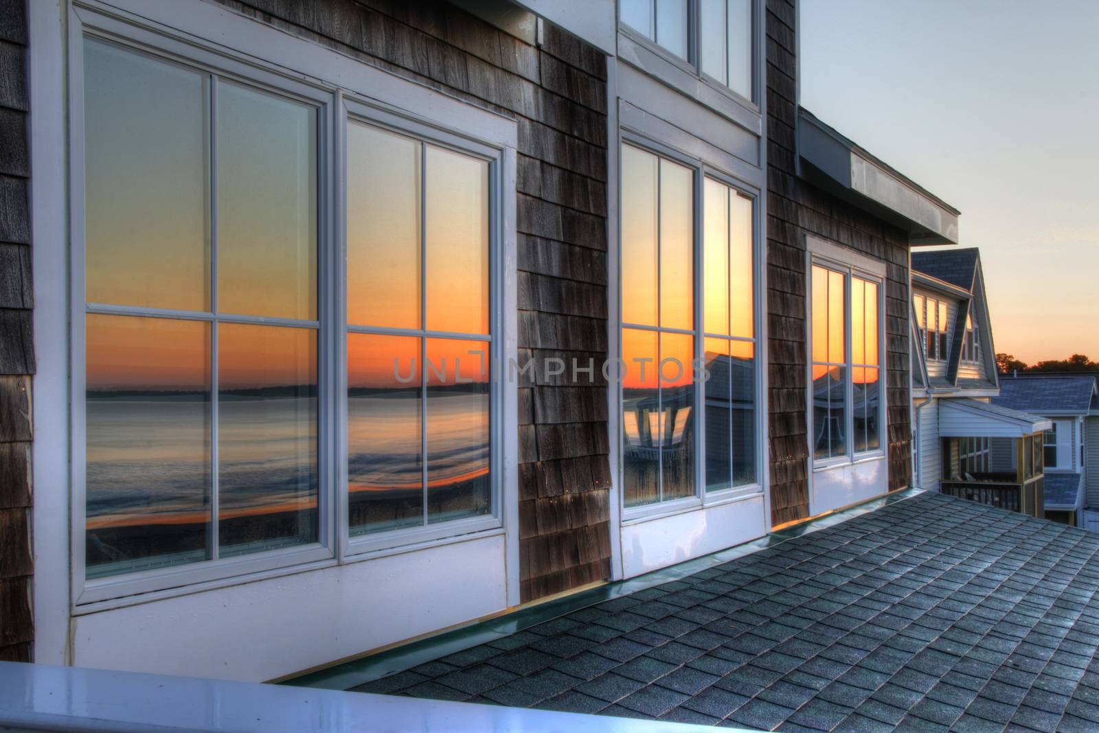 reflection of sunrise through window of a seashore property