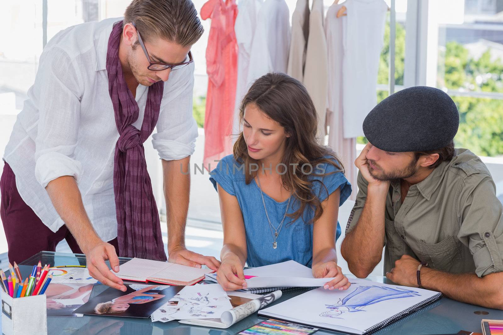 Fashion designer pointing a photo to colleagues