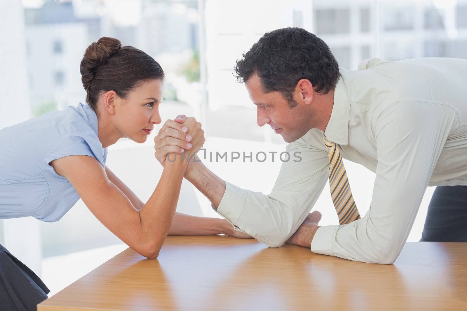 Business people arm wrestling in the office