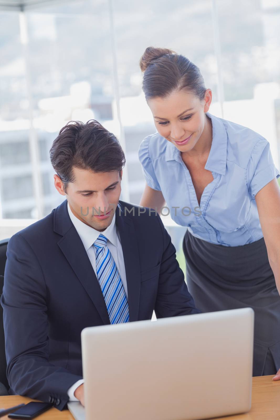 Business people smiling and working together with a laptop in the office