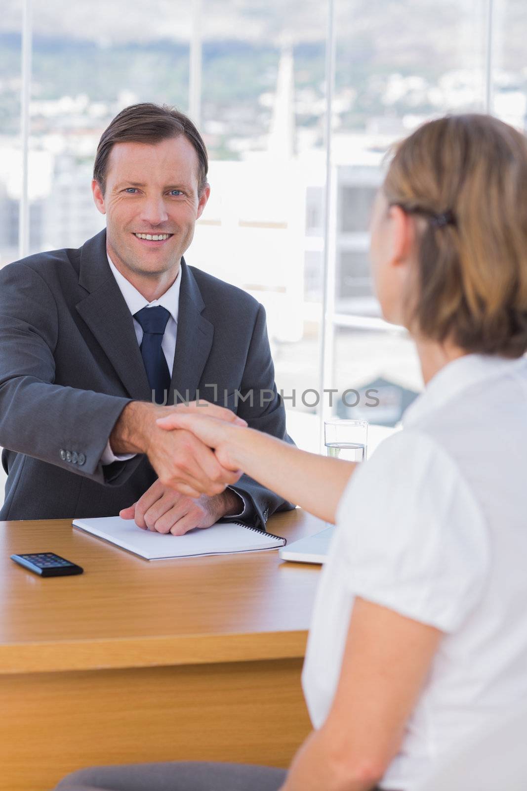 Businessman giving a handshake to a job applicant by Wavebreakmedia