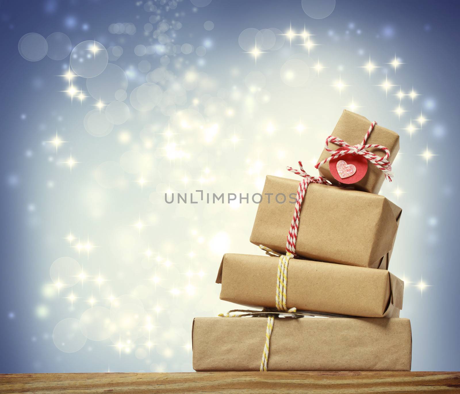 Stack of handmade gift boxes over snowing night background