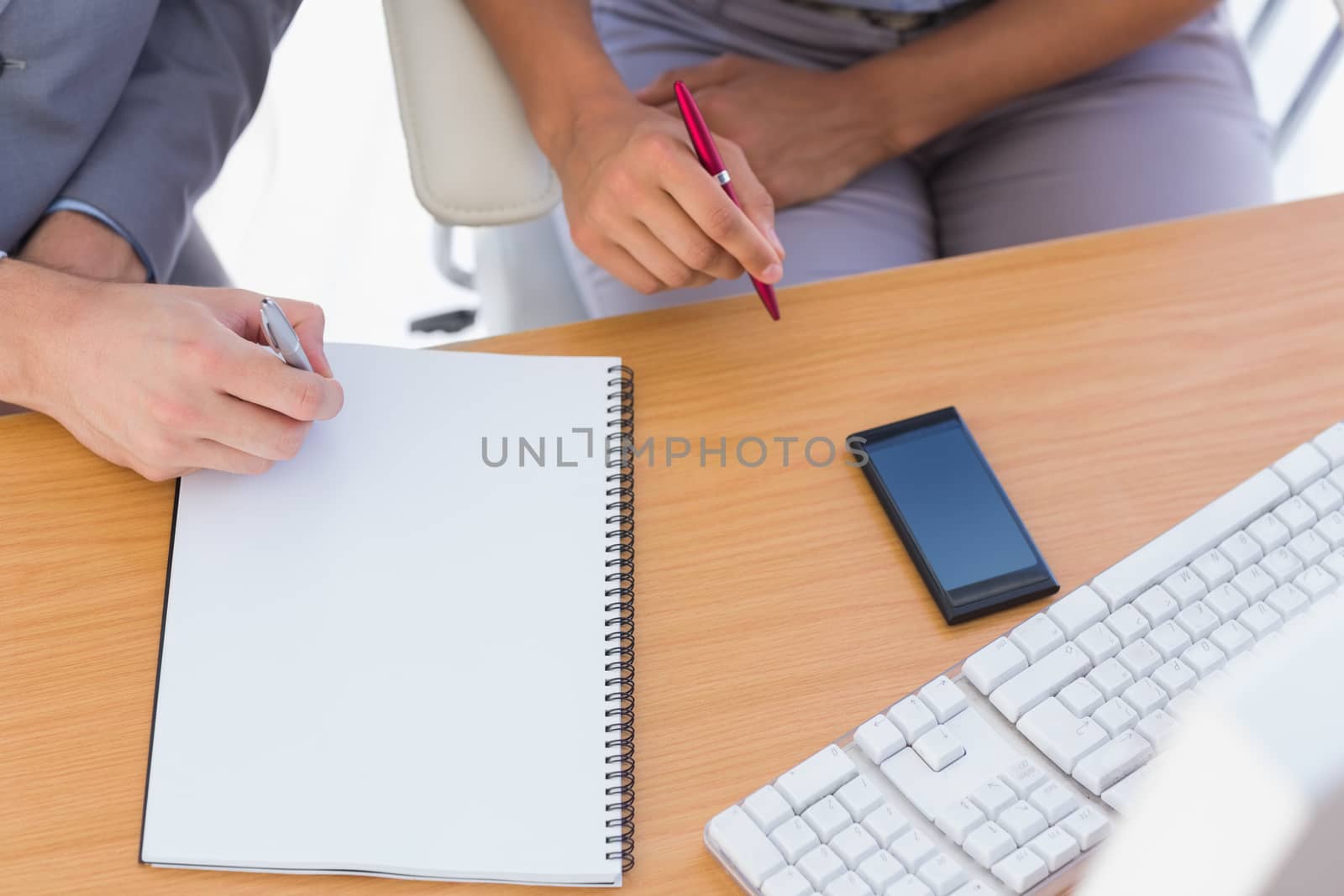 Business people working with notepad at desk overhead shot