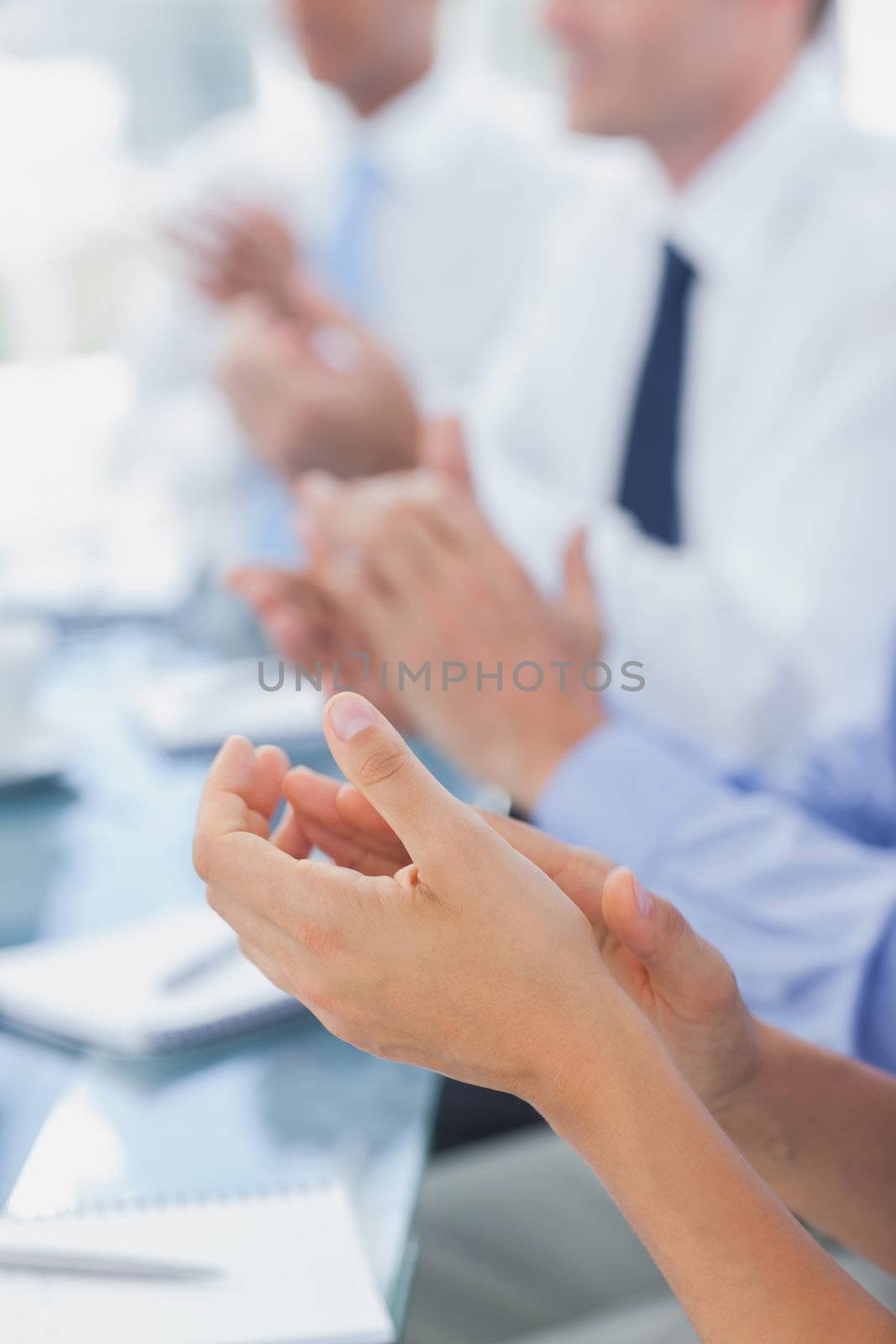 Business people applauding together during a meeting