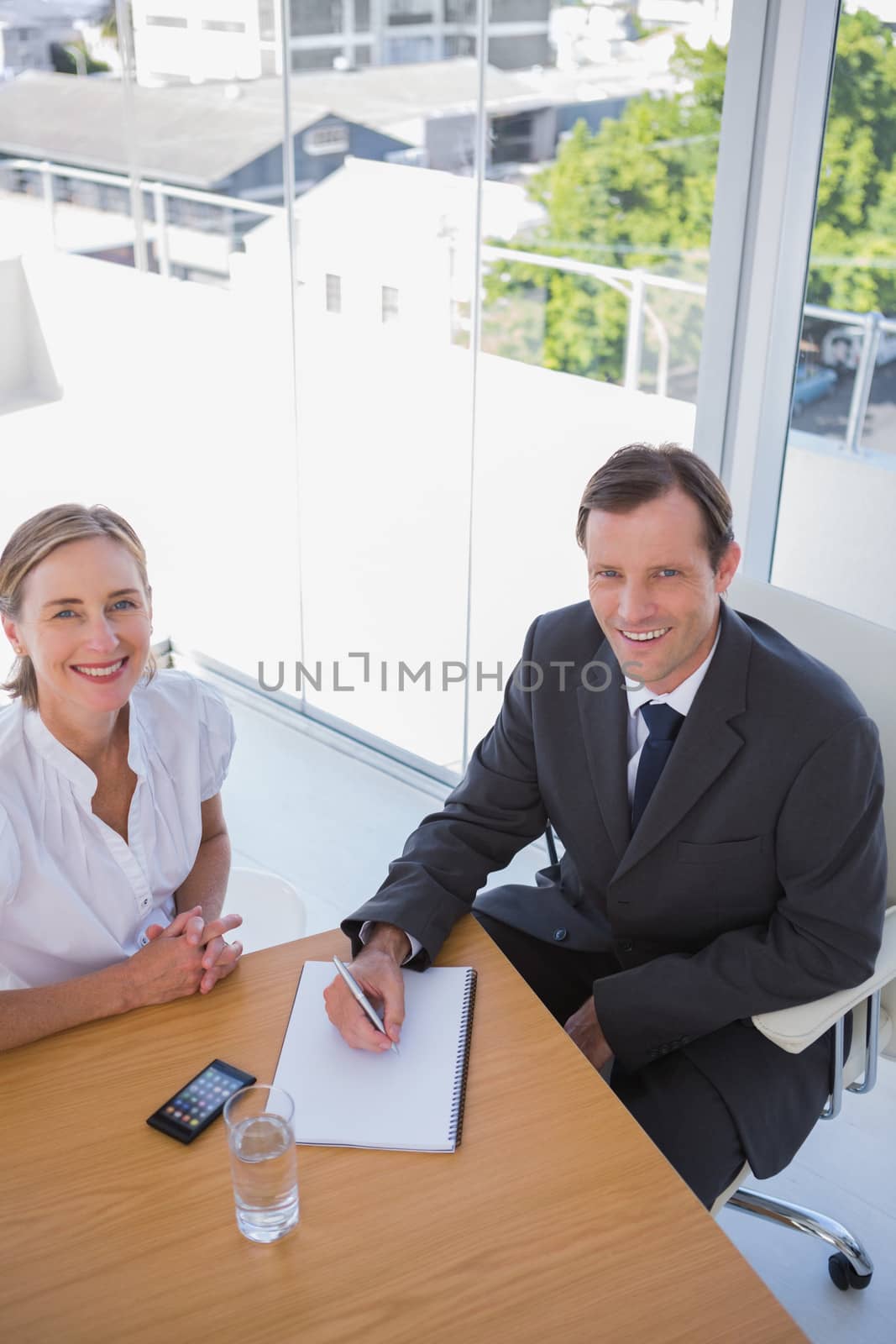 Overhead of cheerful business people taking notes in their office