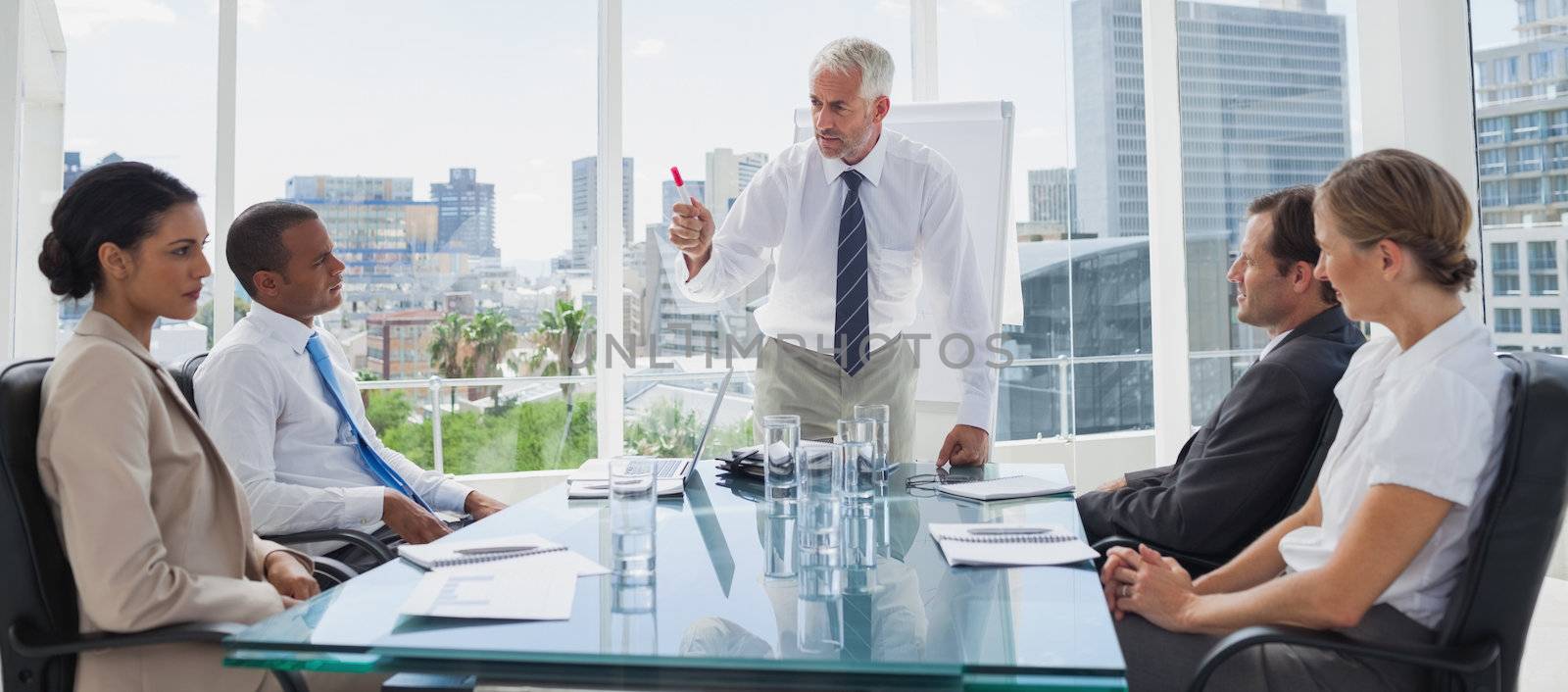 Boss gesturing in front of colleagues by Wavebreakmedia