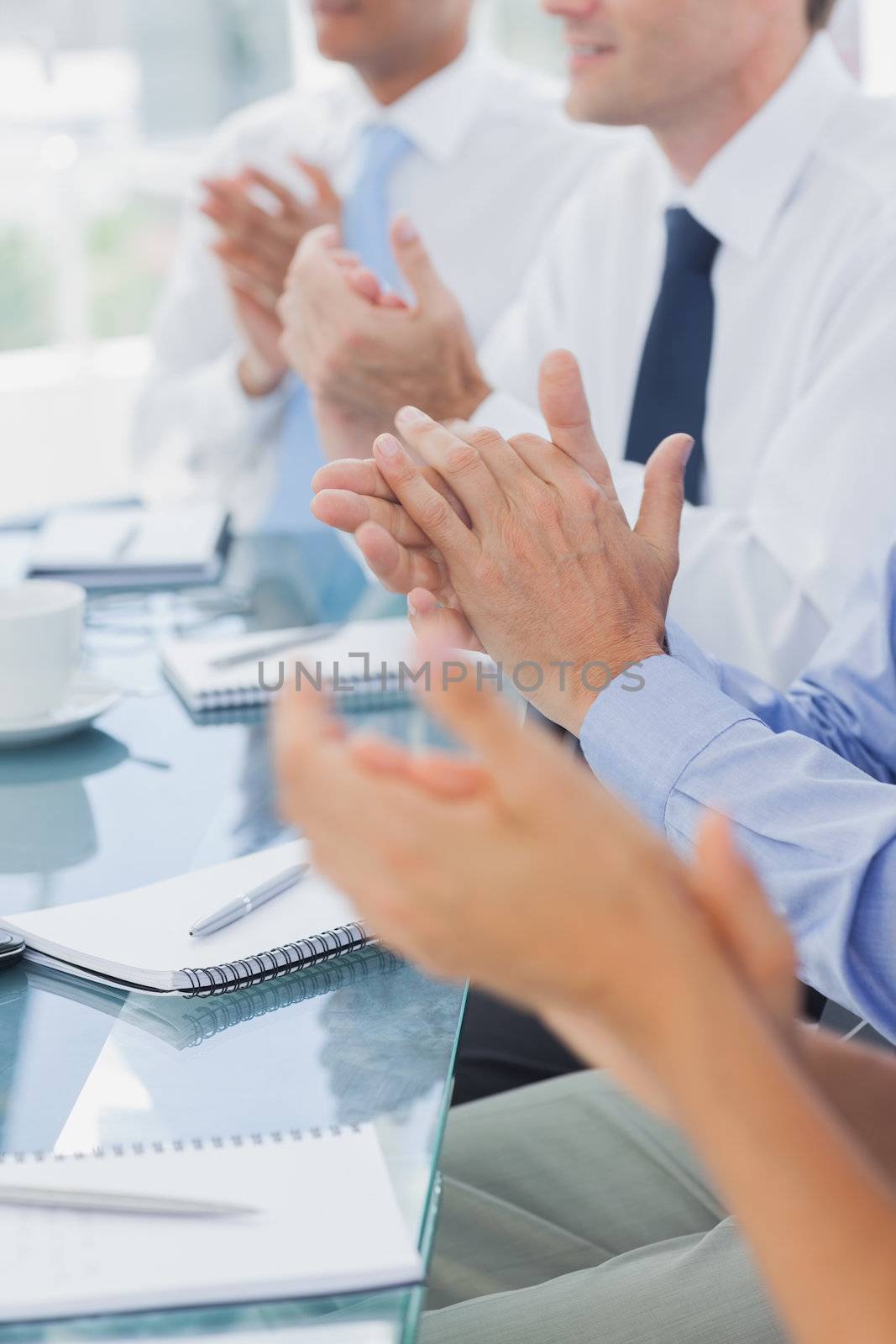 Business people clapping together during a meeting