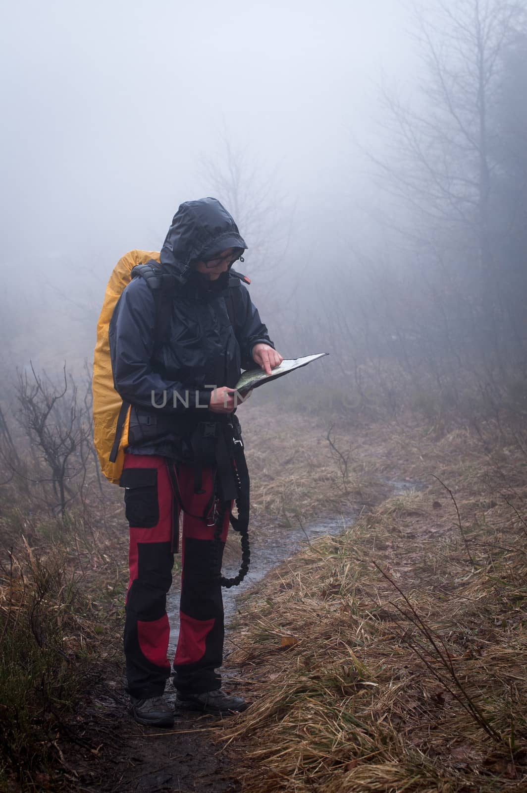 Young woman reading a map in the misty evening