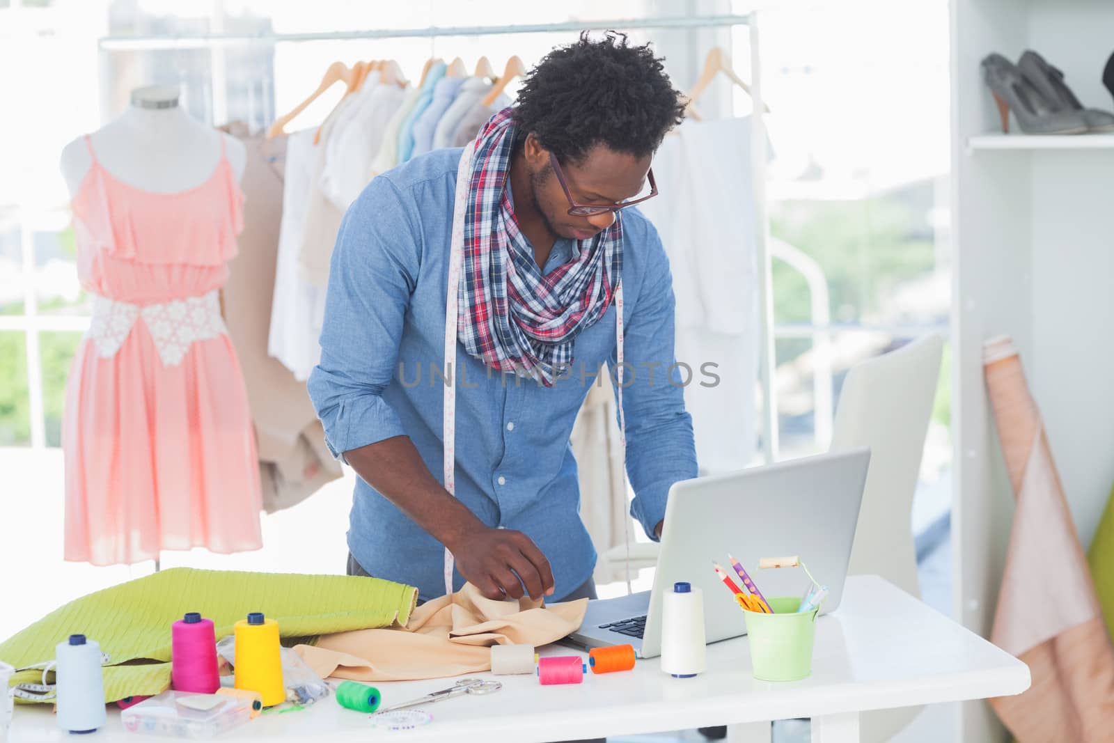 Attractive fashion designer working on laptop in the office