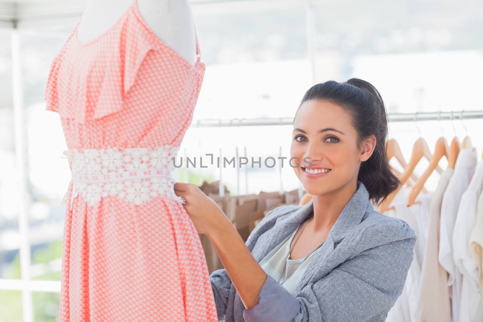 Fashion designer working on dress on a mannequin