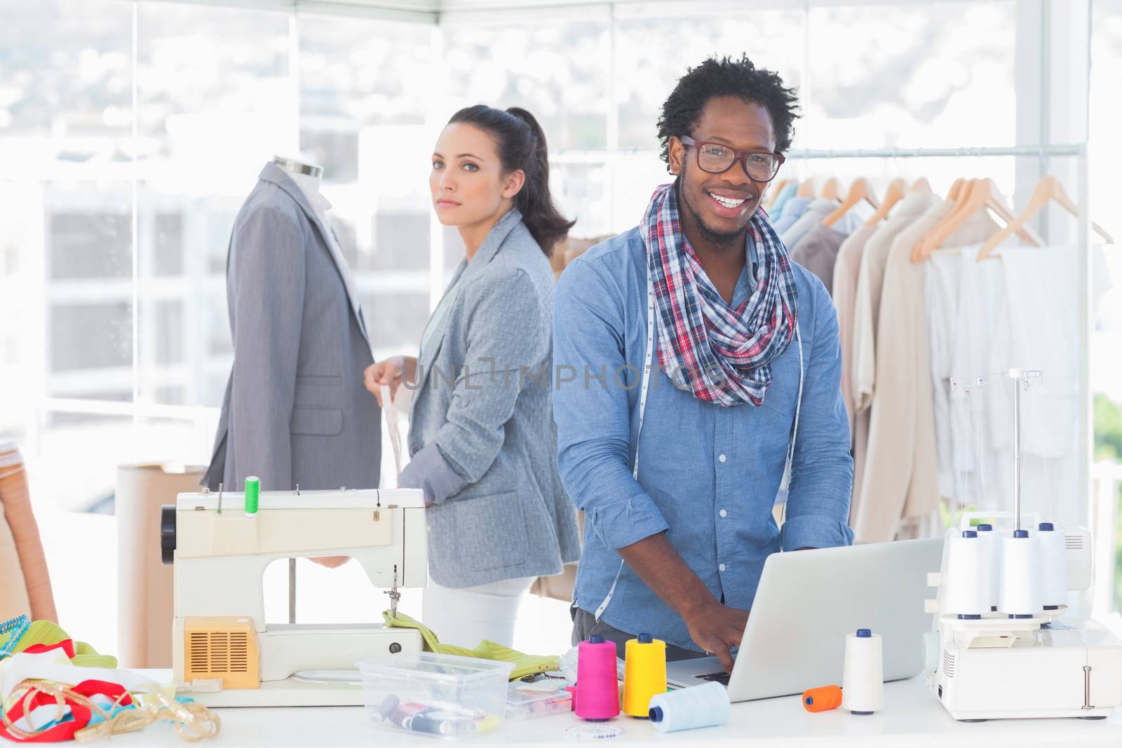 Smiling team of fashion designers looking at camera